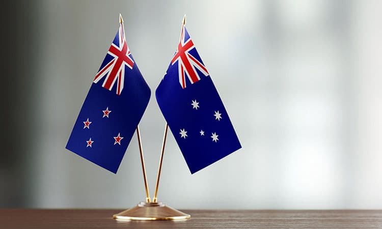 two small flags on a desk, one Australian and one New Zealand